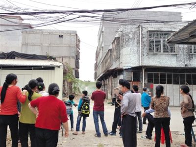 昨日，廣東普寧起火的內(nèi)衣作坊巷口，很多人在圍觀起火居民樓。若不是很多家庭作坊停工，村里很難聚集這么多人。新京報記者 盧美慧 攝